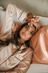 Luxury silk hair scrunchies on woman lying on mulberry silk pillowcase.