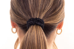 Black silk hair scrunchie in woman's hair. The r and r collective.