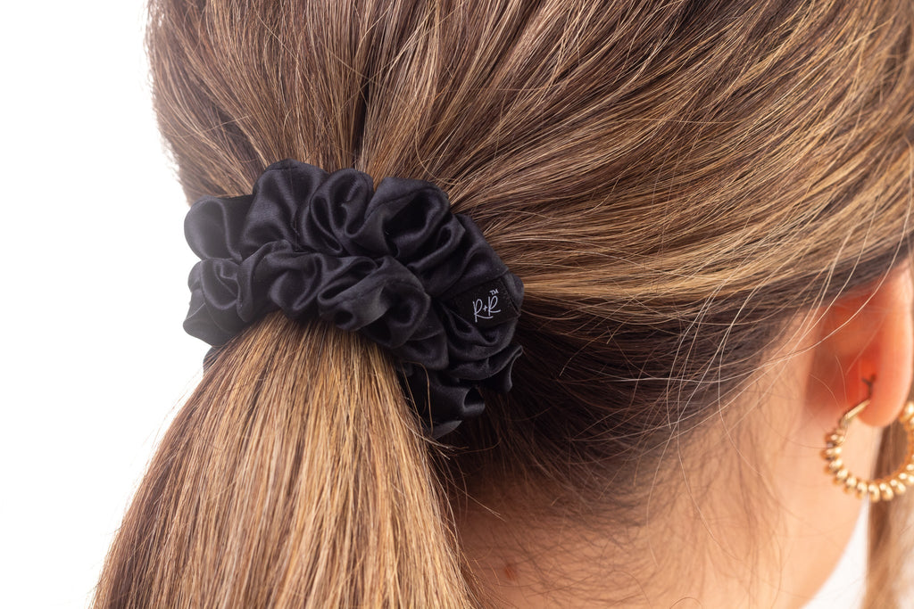 Black medium silk hair scrunchie in woman's hair. The r and r collective.