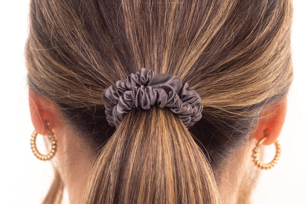 Grey silk hair scrunchie in woman's hair. The r and r collective.